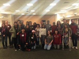 Picture of T.J. standing in a group picture with 22 students and a staff member at Denison University